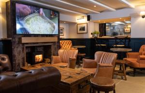 比德內爾的住宿－The Craster Arms Hotel in Beadnell，一间带壁炉的酒吧以及客房内的电视
