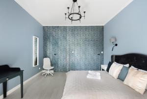 a bedroom with a bed and a desk and a chair at Wiejska Glamour Apartment in Warsaw