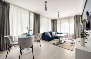 a living room with a blue couch and a table at Wiejska Glamour Apartment in Warsaw