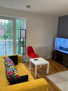 un salon avec un canapé jaune et un fauteuil rouge dans l'établissement Work-Play Stylish, Speedwell Apartment, Free Parking, à Bristol