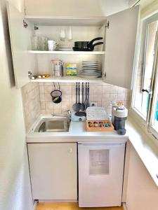 a small white kitchen with a sink and a window at Suite 505 nel cuore di Zurigo in Zürich