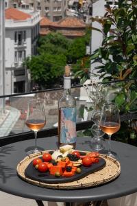 a table with two wine glasses and a plate of food at #FLH -The Koi Apartment, Thessaloniki in Thessaloniki