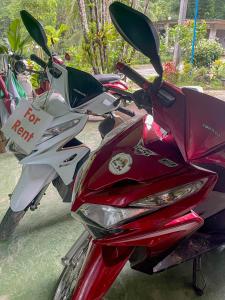 a red motorcycle with a for rent sign on it at Khao Sok Green Mountain View in Khao Sok National Park