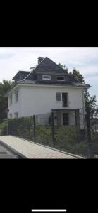 a white house with a fence in front of it at Ferien- Monteurwohnung Sting Siegen in Siegen