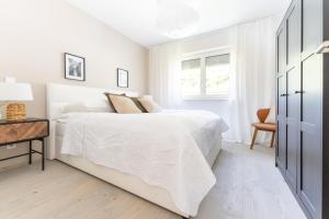 a white bedroom with a white bed and a desk at Spitz Deluxe in Sankt Johann im Mauerthale
