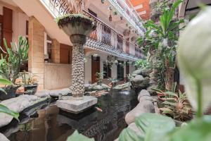 einen Flur mit Teich in einem Gebäude mit Pflanzen in der Unterkunft RedDoorz At Arwiga Hotel in Bandung