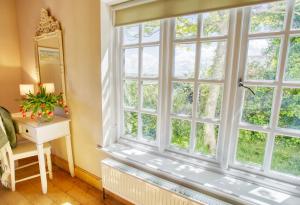 a large window in a room with a table and a mirror at Glan Gors Felin in Llanrhyddlad