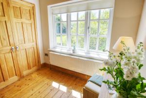 a living room with a large window and wooden floors at Glan Gors Felin in Llanrhyddlad