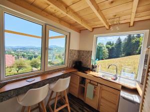 a kitchen with two large windows in a tiny house at Rainbow Chalet in Bran