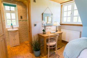a bedroom with a desk and a bed and a mirror at Glan Gors Felin in Llanrhyddlad