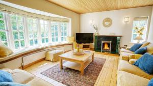 a living room with a couch and a fireplace at Glan Gors Felin in Llanrhyddlad