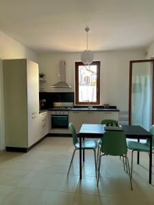 uma cozinha com uma mesa e cadeiras numa cozinha em La dimora del Cardinale em LʼAquila