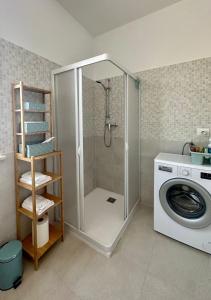 łazienka z prysznicem i pralką w obiekcie La dimora del Cardinale w mieście LʼAquila