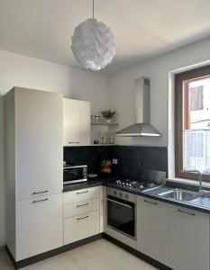 een keuken met witte kasten en een fornuis met oven bij La dimora del Cardinale in LʼAquila