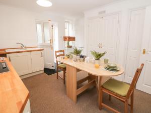 een keuken met een tafel en stoelen in een kamer bij Garden Apartment in Buxton