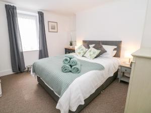 a bedroom with a bed with green towels on it at Garden Apartment in Buxton
