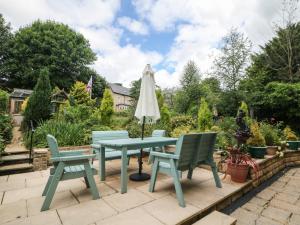 a table and chairs and an umbrella on a patio at Garden Apartment in Buxton