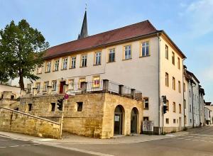 an old stone building with a steeple on a street at Spacious family apartment in Bamberg in Bamberg