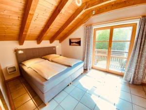 ein Schlafzimmer mit einem Bett und einem großen Fenster in der Unterkunft Urlaubshof Bechteler in Waltenhofen