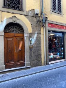フィレンツェにあるda I' Gini GuestHouseの木製の扉と店窓のある建物