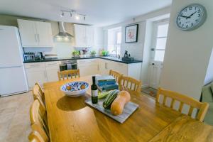 a kitchen with a wooden table with a plate of food at Tyn Lon in Moelfre