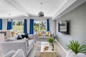 a living room with blue curtains and a couch at Cherry Lodge, 14 Roadford Lake Lodges in Lifton