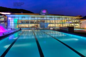 una piscina di fronte a un edificio di notte di Die Dorfvilla a Maishofen