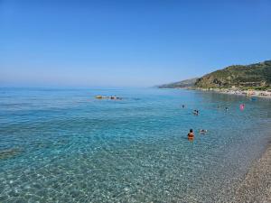 a group of people in the water at a beach at Eremo sul Mare in Marina di Fuscaldo