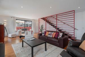 uma sala de estar com um sofá e uma escada em Holiday home by the sea Pipas do Avô - Seixal em Porto Moniz