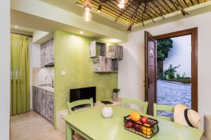a kitchen and a dining room with a green table and a table sidx sidx sidx at Agrilionas Hotel in Marathokampos