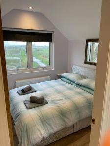 a bedroom with a bed with two pillows on it at Falabella Suite with amazing views of stud farm. in Great Driffield