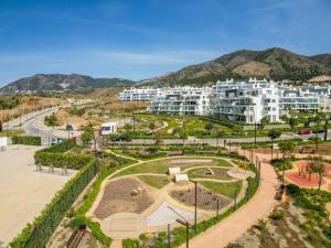 un parc en face d'un grand bâtiment blanc dans l'établissement HigueronRentals Live Work Enjoy, à Fuengirola