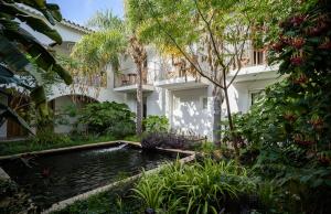a house with a pond in front of a building at Sant Efis Hotel in Pula