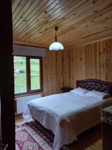 una camera con un grande letto e un soffitto in legno di Saklı Bahçe Suite a Uzungöl
