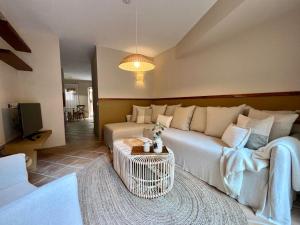 Una sala de estar con un sofá blanco y un televisor. en Apartaments Can Gibert, en Castelló d'Empúries