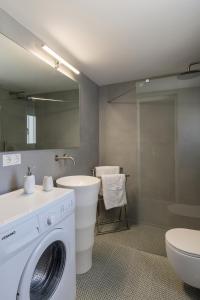 bagno con lavatrice e lavandino di Vivianna’s guest house a Ermoupoli
