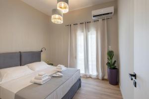 1 dormitorio con 1 cama con toallas en Vivianna’s guest house, en Ermoupoli