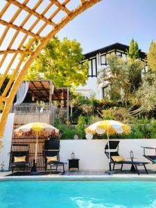 a patio with chairs and umbrellas next to a pool at Quand la ville dort in Agen
