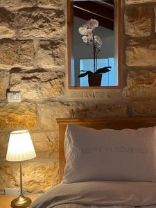 a bedroom with a bed and a window with a flower pot at Via Maria Boutique Suites In The Middle Of The city in Haifa