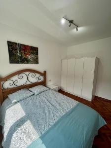 1 dormitorio con 1 cama y una pintura en la pared en RAXEL - MIÑO, en Miño