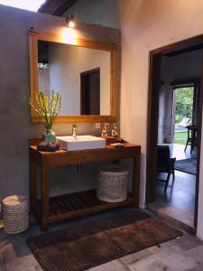 La salle de bains est pourvue d'un lavabo et d'un miroir. dans l'établissement Uma Mupu Retreat, à Gianyar