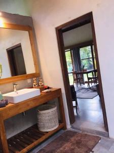 ein Bad mit einem Waschbecken und einem Spiegel in der Unterkunft Uma Mupu Retreat in Gianyar
