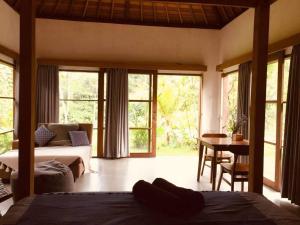 a bedroom with a bed and a desk with a table at Uma Mupu in Gianyar +151 photos
