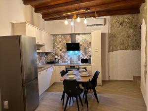 cocina con mesa, sillas y nevera en Camara House, en Pitsidia