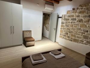 Habitación con pared de piedra y 2 toallas en Camara House, en Pitsidia
