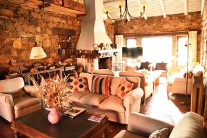 a living room with couches and a stone wall at Hosteria Casagrande in Tandil