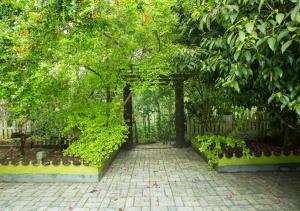 un jardín con una puerta y una pasarela de ladrillo en Spezia Private Plantation Bungalow Thekkady by VOYE HOMES, en Thekkady
