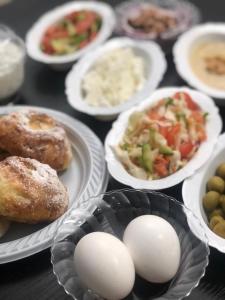 una mesa cubierta con platos de comida con huevos y verduras en Breezot Yam, en Nahariyya