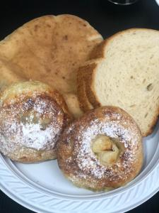 dos bagels y pan en un plato blanco en Breezot Yam, en Nahariyya