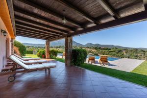 an outdoor patio with a wooden pergola at Costa Smeralda House in Cugnana